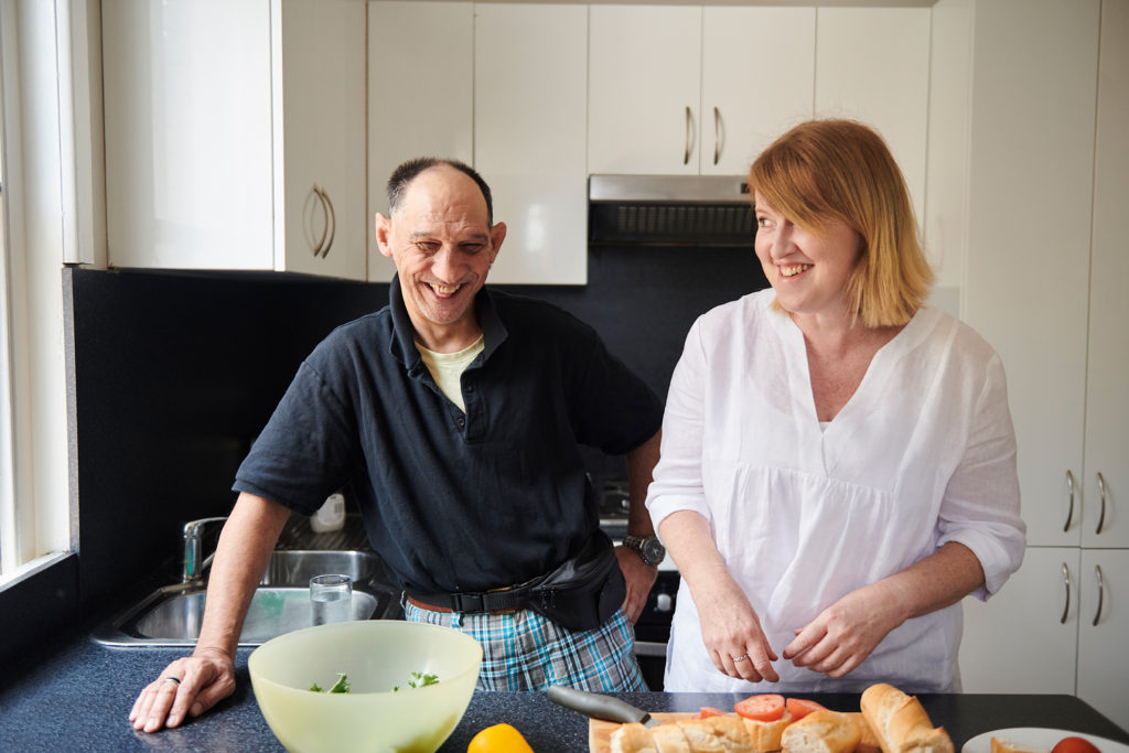 Lady in white shirt with guy in black t-shirt smiling