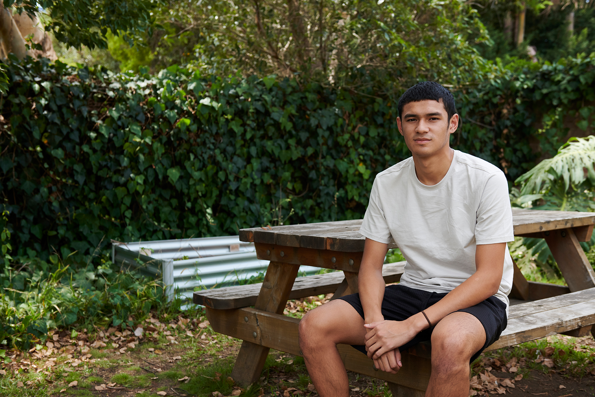 young man sitting at park bench
