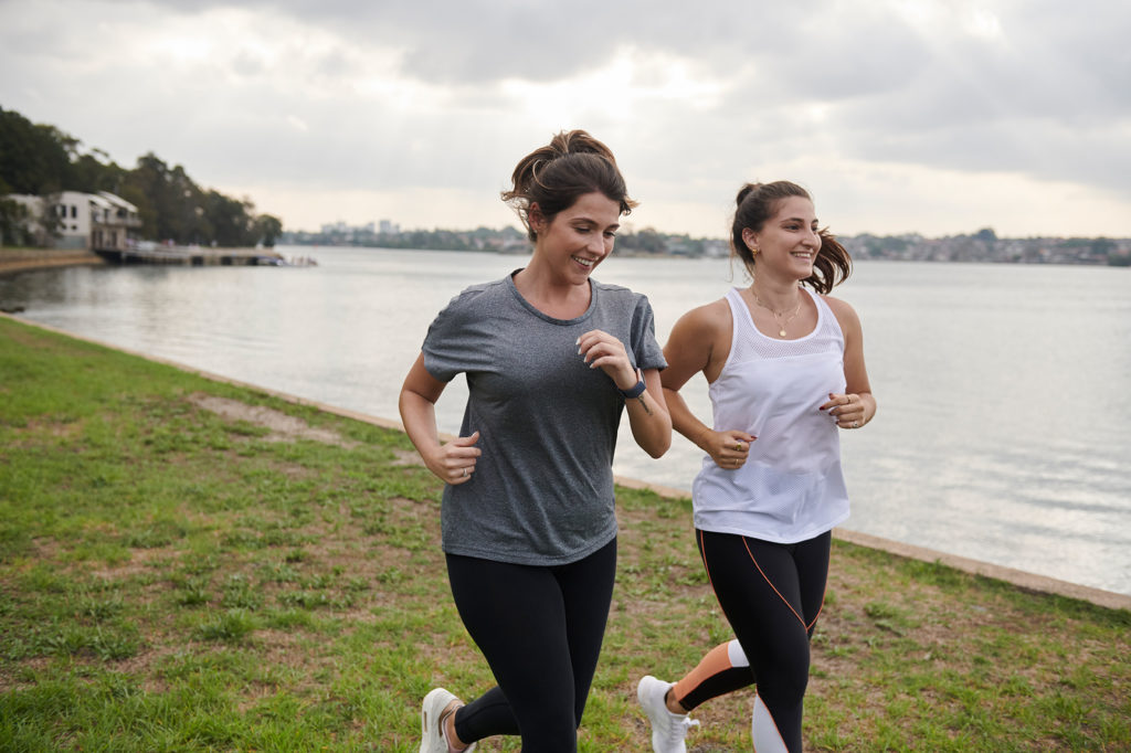 2 girls running along the shoreline