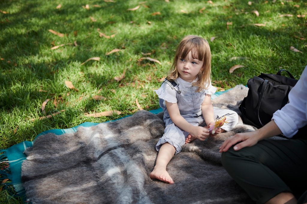 Little girl sitting down in grass