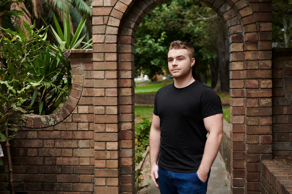 Young man standing in front of park