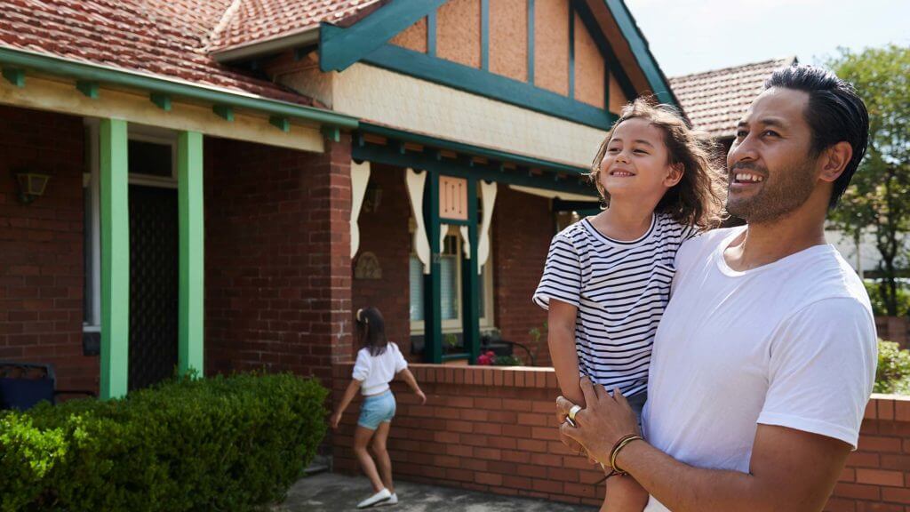 Father holding daughter outside