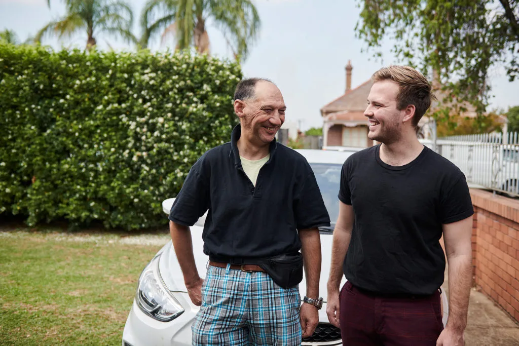 five dock adult NDIS carer helping disabled person in front of grey car