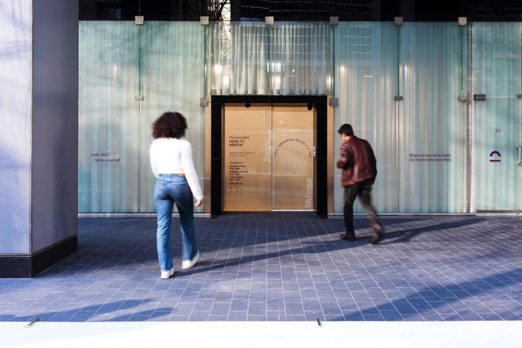 woman walking into building doorway, parramatta head to health