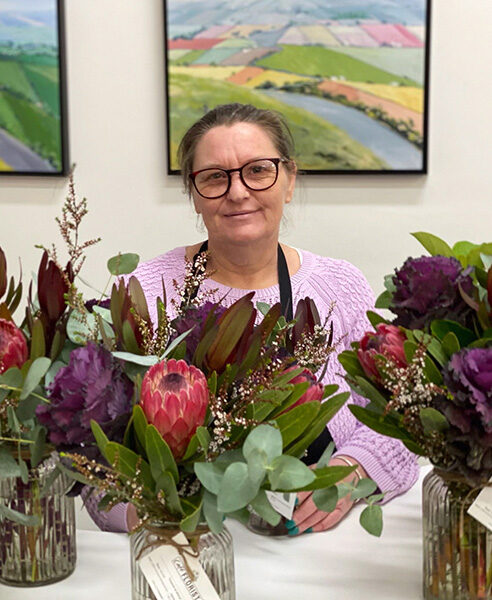 Cassandra is surrounded by bouquets at the florist where she works