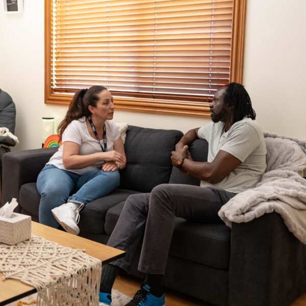 Stride worker sitting with participant on the lounge having a conversation