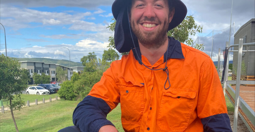 Alex smiles at the camera in his work gear