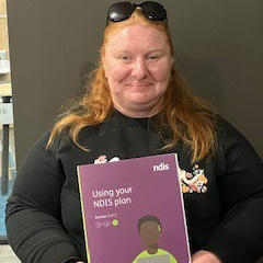 Headshot of Alison holding NDIS plan book