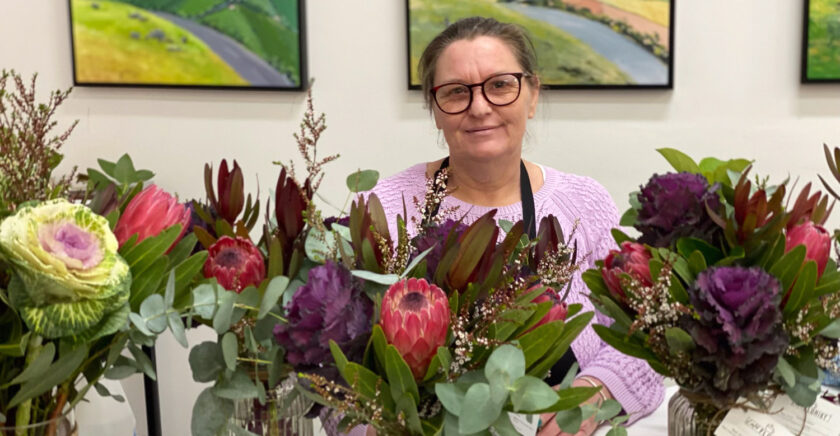 Cassandra is surrounded by bouquets at the florist where she works