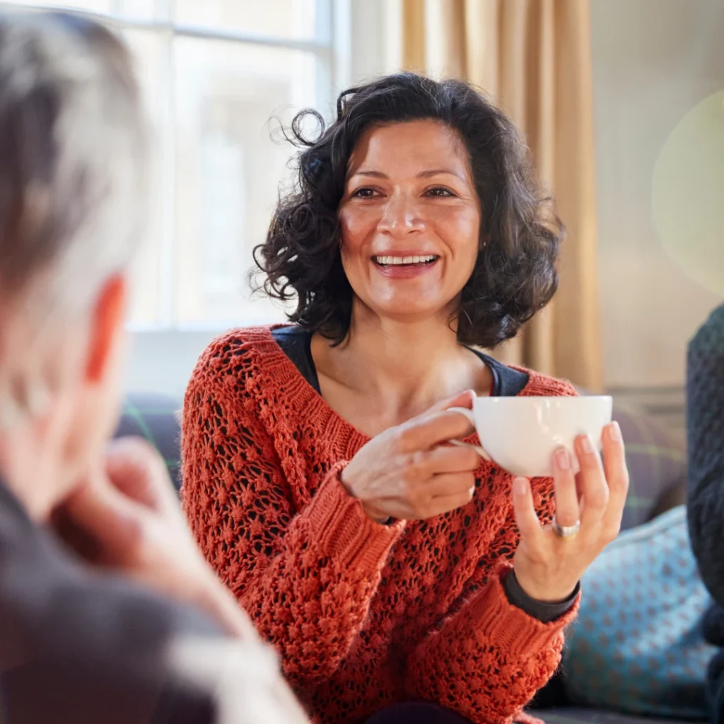 Woman sipping tea talking to friend