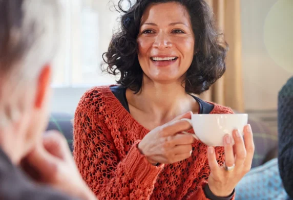 Woman sipping tea talking to friend