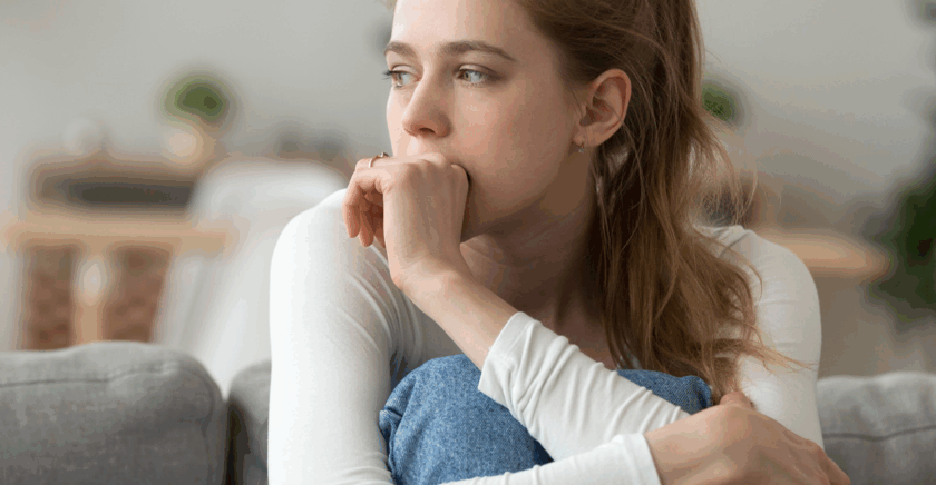 Young woman holding knees looking off to side