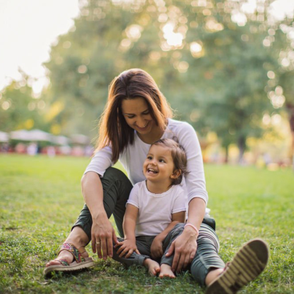 Woman and child sitting on grass together