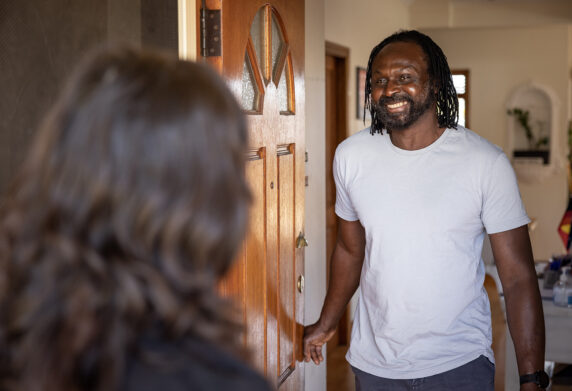 Man welcoming someone at the front door