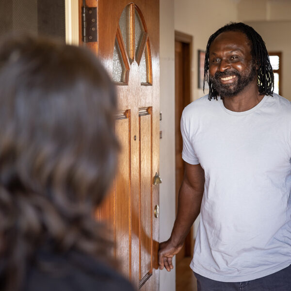 Man welcoming someone at the front door