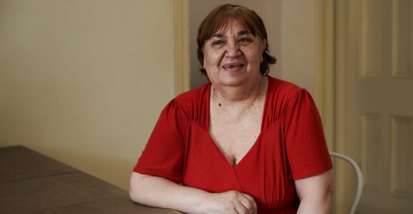 Woman wearing red shirt sitting on chair smiling