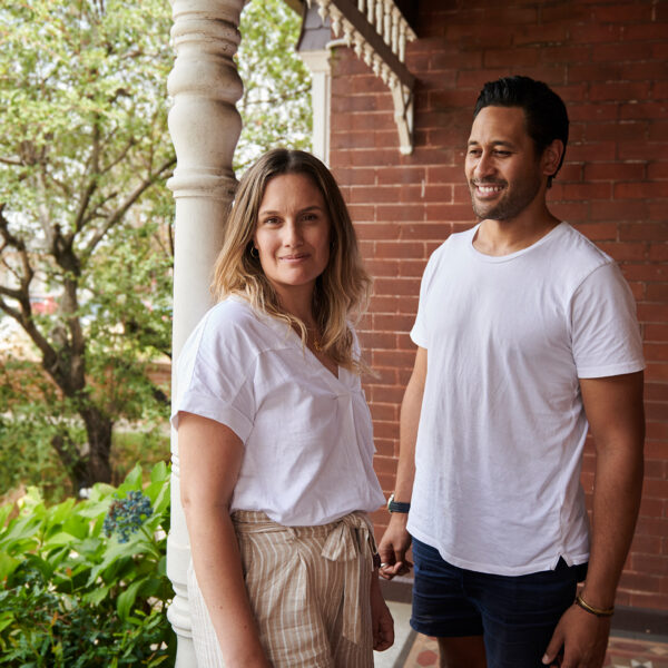 Woman and man standing on front porch smiling