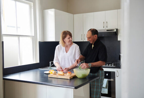 Supported living resident cooks with their carer.