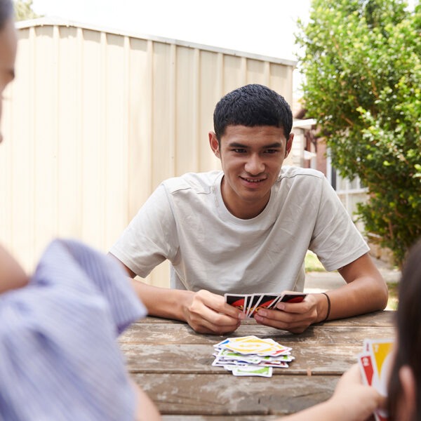 Young people playing cards in a backyard