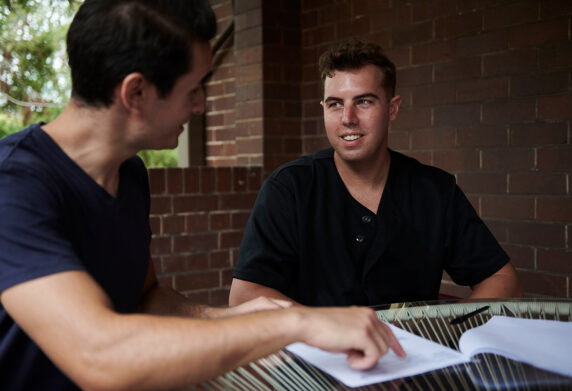 Two men talking and pointing to paper