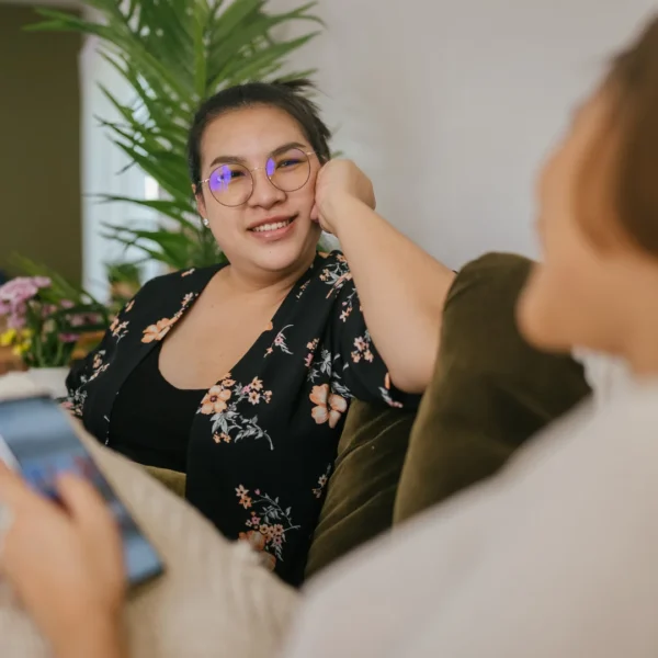 Two women sitting on lounge smiling