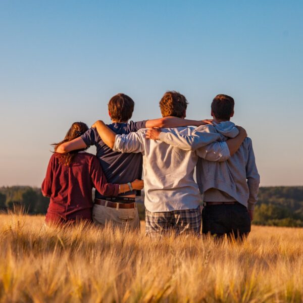 Three young boys and one young girl standing with their arms around each other
