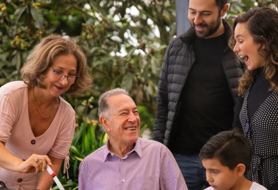 Older man surrounded by family looking happy
