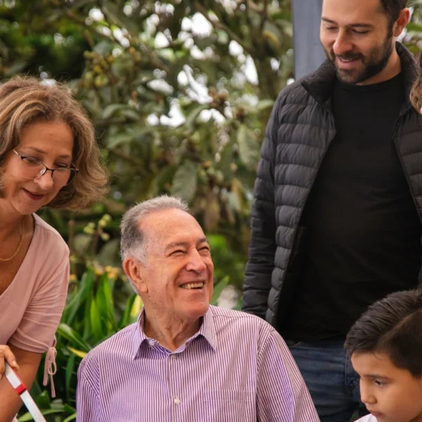 Older man surrounded by family looking happy