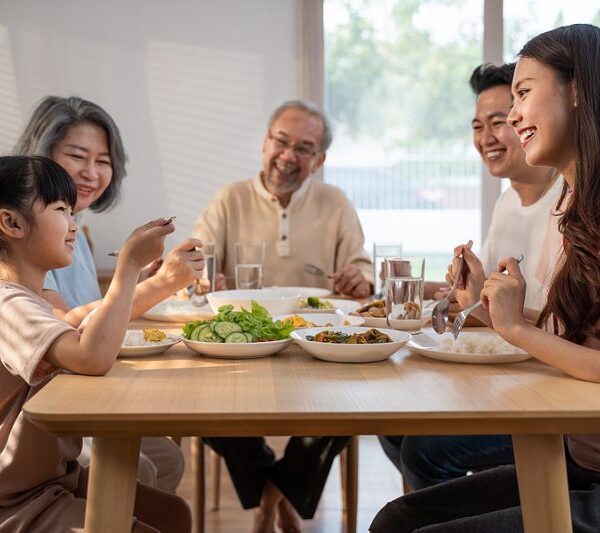 Family of 5 sitting around eating smiling and laughing together