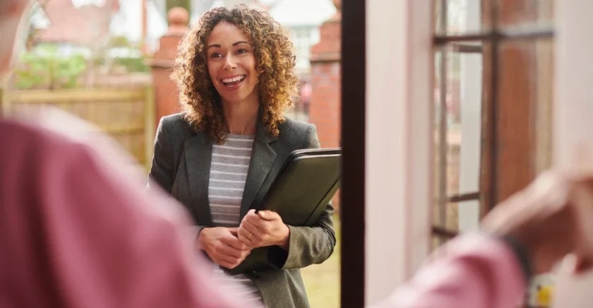 Woman at door talking to someone in their house