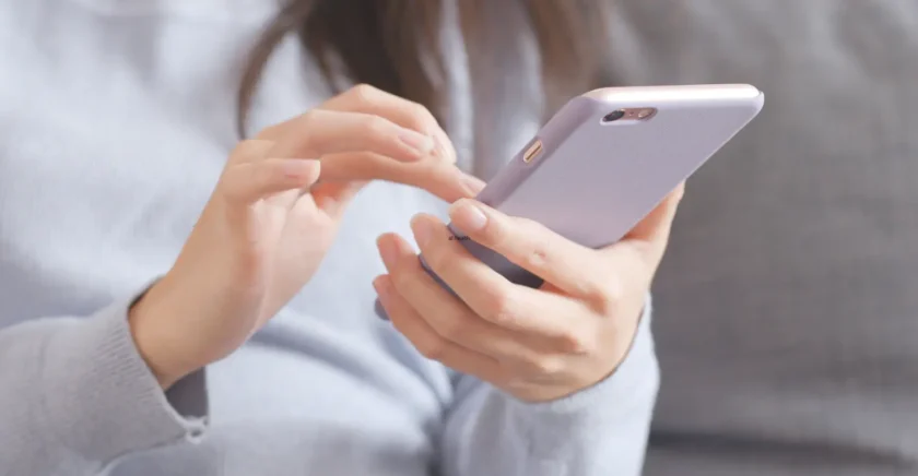 Close up of woman typing on phone