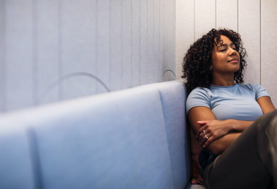 A young person sits peacefully on a couch