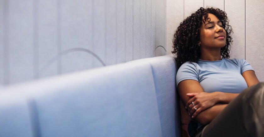 A young person sits peacefully on a couch