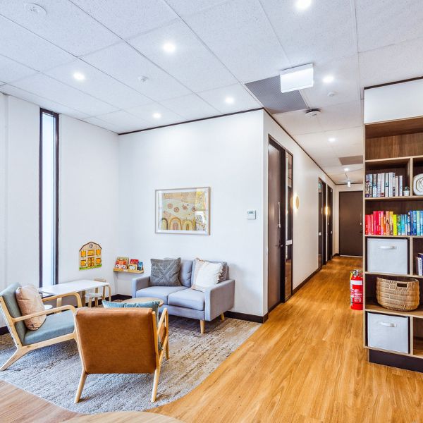 Reception area with seating, leading into hallway for private consultation rooms