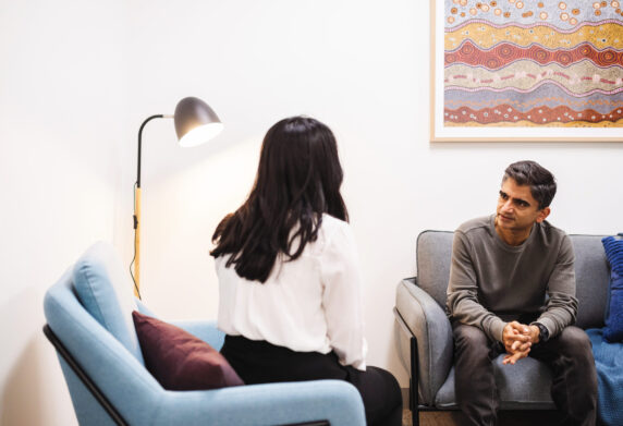 Private consultation room with two people talking