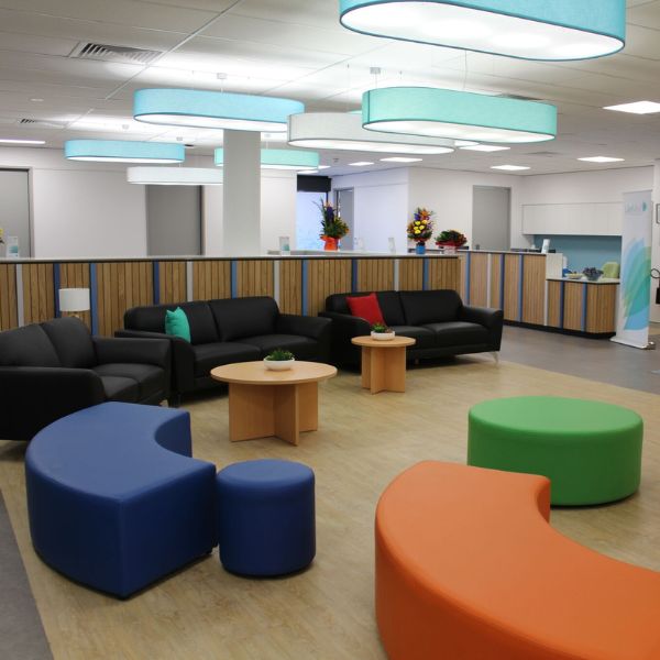 Colourful seating area in foyer with 3 black lounges