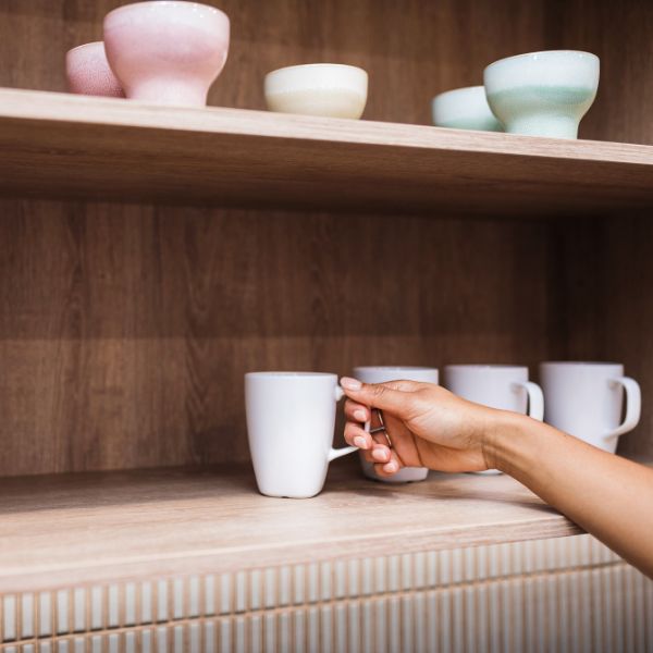 Parramatta Kitchen shelves stocked with mugs and bowls, person selecting and holding a mug