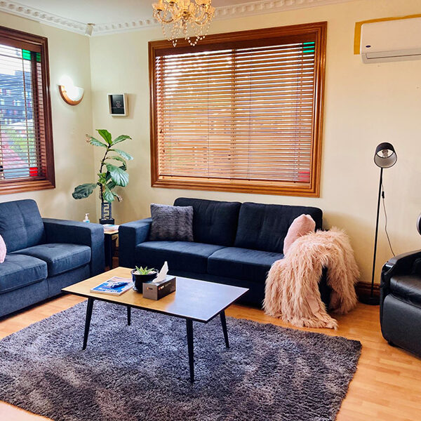 The visitor lounge is cozy and bright with big windows and comfy couches