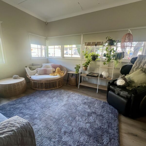 Well-lit space with multiple sitting areas, greenery and plush rug