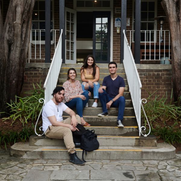 four youth people on steps smiling at camera
