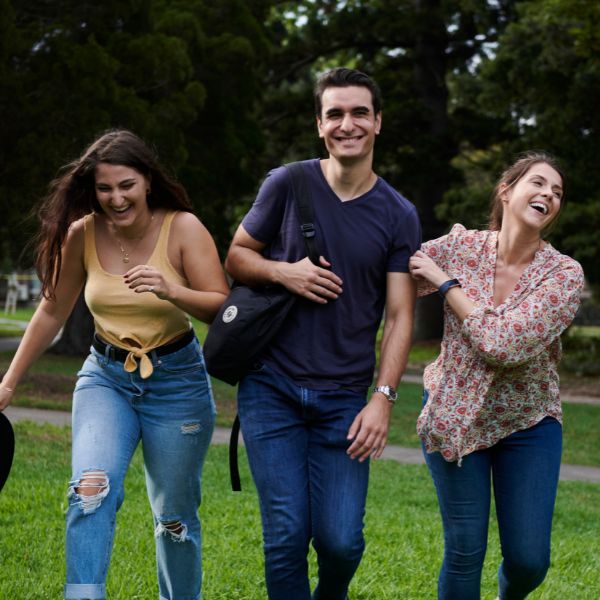 three youth people walking and laughing with each other in the park