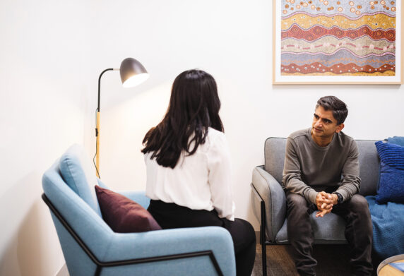 Client and support working chatting in a consultation room.