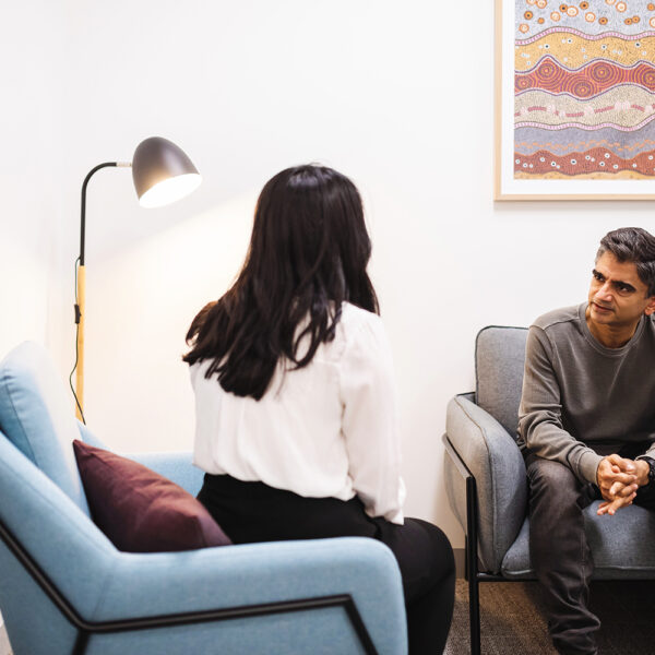 Client and support working chatting in a consultation room.