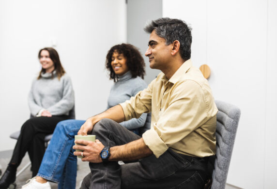 two females and male sitting in room
