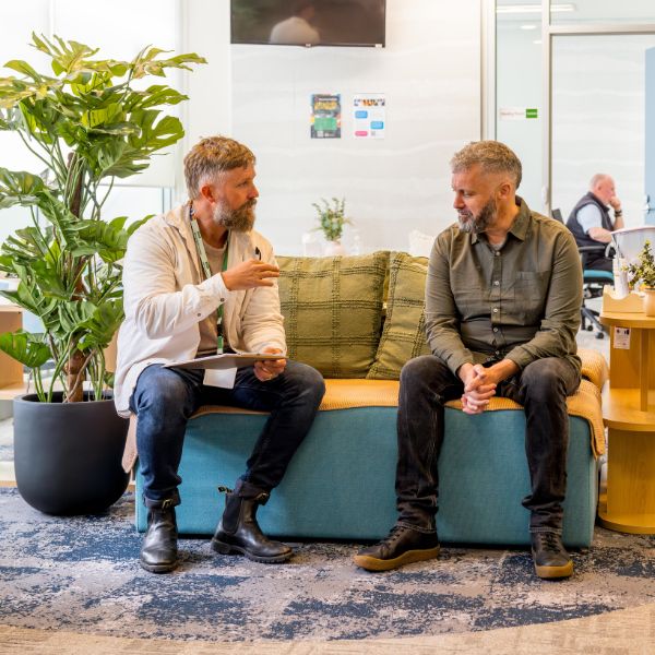 Peer worker sitting and talking with somebody in waiting/sitting area