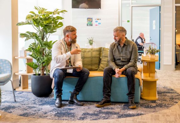 Peer worker sitting and talking with somebody in waiting/sitting area