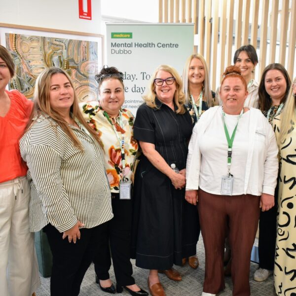 Dubbo MMHC team smiling in front of the Dubbo pull up banner