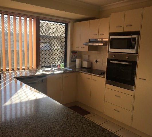 Kitchen space with oven, microwave, dishwasher electric cooktop.
